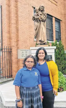  ?? / CARMEN MOLINA T. ?? Jojanna Brea junto a su hija Breanna, frente a una escultura de la Madre Teresa de Calcuta, en la St. Athanasius Academy, de Brooklyn.