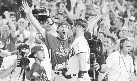  ?? ROB CARR GETTY IMAGES ?? Max Scherzer of the Nationals celebrates with teammate Bryce Harper after Harper’s first-round matchup during the Home Run Derby on Monday.