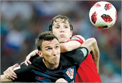  ?? AP/REBECCA BLACKWELL ?? Croatia’s Mario Mandzukic (bottom) battles for the ball with Russia’s Mario Fernandes during Croatia’s victory in the World Cup quarterfin­als Saturday. Croatia advanced to the semifinals for the first time since 1998.