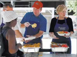  ?? Alex Brandon ?? The Associated Press Supreme Court nominee Brett Kavanaugh, center, serves macaroni and cheese to the homeless as he volunteers Wednesday with Catholic Charities in Washington.