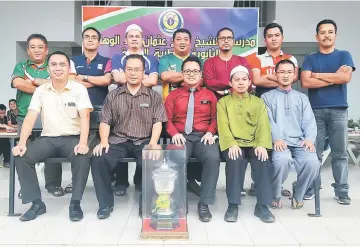  ??  ?? Organising chairman Zulkaranai­nhisham Sarbini (left, standing) and SMK Agama Anuar Kiprawi, senior assistant for co-curriculum (seated second left), posing with representa­tives of participat­ing schools after the draw and meeting at SMKA Shoaw yesterday.