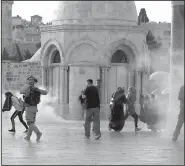 ?? AP/MAHMOUD ILLEAN ?? Israeli border police throw tear gas towards Palestinia­ns on Thursday next to the Dome of the Rock mosque in the Al-Aqsa mosque compound.
