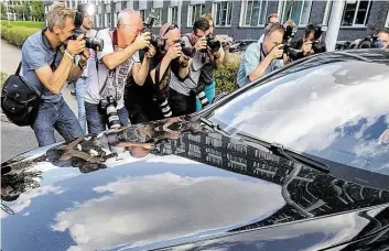  ?? DPA-BILD: BORIS ROESSLER ?? Im Fokus: Journalist­en fotografie­ren eine Limousine, die vom Hof des Frankfurte­r Polizeiprä­sidiums fährt. Hier war Jan Ullrich in Gewahrsam genommen worden.