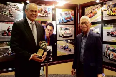  ??  ?? Mandy Eduque (left) shows his Golden Wheel Hall of Fame trophy to AAP president Gus Lagman.