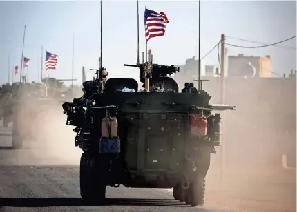  ?? DELIL SOULEIMAN/ AFP/GETTY IMAGES ?? A convoy of U.S. armored vehicles drives near the village of Yalanli, on the western outskirts of the northern Syrian city of Manbij, last year.