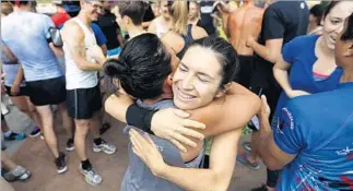  ??  ?? THE MORNING WORKOUT starts with runners gathering at the Bowl for warm-ups and hugs.