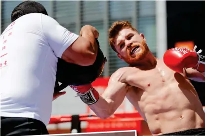 ?? AP ?? Date with destiny: Canelo hits the pads and (left) the tattoo that bears his mantra