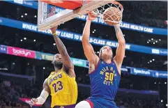  ?? USA TODAY SPORTS ?? Nuggets forward Aaron Gordon dunks ahead of Lakers forward LeBron James during the first half of their play-off game at Crypto.com Arena.