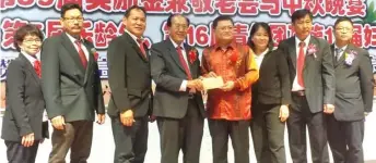  ??  ?? Huang (fourth right) presents the grant cheque to chairman Kapitan Law Hieng Ping.