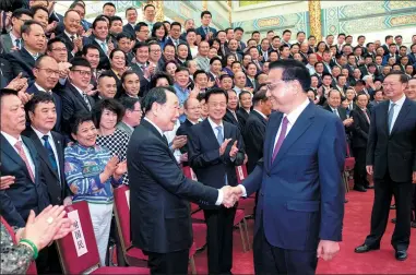  ?? LI XUEREN / XINHUA ?? Premier Li Keqiang meets representa­tives of the second overseas Chinese business conference at the Great Hall of the People in Beijing on Monday. Li encouraged overseas Chinese to contribute by investing talent and resources.