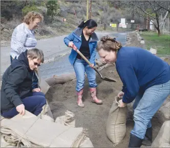  ?? DALE BOYD/Penticton Herald ?? Sportsmens Bowl Road residents Glady Morin, back left, and Brenda Walls get help with sandbaggin­g from friends and neighbours Monday.They have been working for three weeks to try to protect their properties from high water levels.