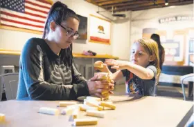  ??  ?? Jess Begley, left, and Quinn Begley play Jenga at Napa Smith Brewery in Vallejo.