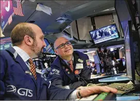  ?? SPENCER PLATT / GETTY IMAGES ?? Traders work on the floor of the New York Stock Exchange on Tuesday. The Dow Jones industrial average finished up over 400 points as China made statements that defused trade tensions between Beijing and Washington.