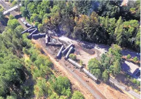  ?? SOURCE: WASHINGTON STATE DEPT. OF ECOLOGY ?? Burned oil tank cars lay scattered after a train derailed and burned near Mosier, Ore., in June. The nation’s largest railroad has agreed to more thorough inspection­s.