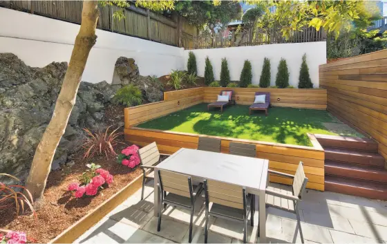  ?? Photos by Circle Visions ?? Above: The Potrero Hill home on 548 Rhode Island St. offers a landscaped yard with a raised lawn and built-in planter boxes. Below: The kitchen boasts profession­al appliances and a Calcutta marble island with waterfall edges.