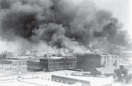  ??  ?? Smoke billows over Tulsa, Oklahoma, in 1921 during riots that resulted in the killings of hundreds of people in a black business district.