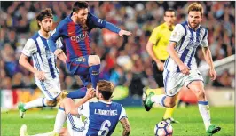  ?? AFP ?? Messi (top C) jumps over Real Sociedad's defender Inigo Martinez Berridi (bottom) during the Spanish league football match FC Barcelona vs Real Sociedad at the Camp Nou stadium in Barcelona on Saturday.