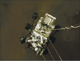  ?? NASAVIAAP ?? The Perseveran­ce rover is lowered toward the surface of Mars during its powered descent Thursday.