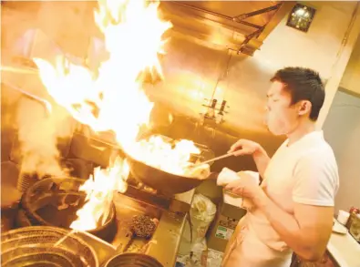  ?? Photos by Eric Luse / The Chronicle 2009 ?? Anthony Myint cooks in the kitchen of Lung Shan, a Chinese restaurant his Mission Street Food moved into for two nights a week when it outgrew its origins in a rented food truck on a Mission District corner.