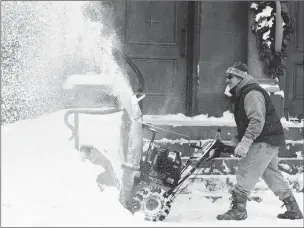  ??  ?? Frank Necci clears snow Friday from St. Andrews Catholic Church in Erie, Pa. The cold weather pattern was expected to continue through the holiday weekend and likely longer, according to the National Weather Service.