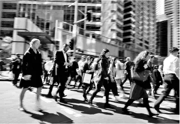  ?? - Reuters photo ?? Office workers and shoppers walk through Sydney’s central business district in Australia. The ATO will investigat­e more than 20 million internatio­nal visa holders and foreign students using data-matching audits to catch tax avoidance and enforce...