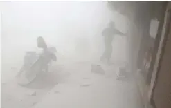  ??  ?? HAMOURIA, Syria: A Syrian man runs for cover amid the dust and smoke following a reported government air strike on the rebel-controlled town of Hamouria, in the eastern Ghouta region. — AFP