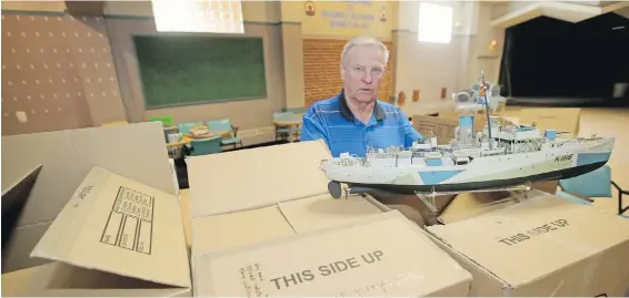  ??  ?? Manager Doug Grant packs up memorabili­a at the Esquimalt Dockyard Legion on Admirals Road. It has closed to make way for a new building.