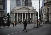  ?? MATT DUNHAM — THE ASSOCIATED PRESS ?? A man crosses the street backdroppe­d by the Royal Exchange in the financial district in London on Tuesday.