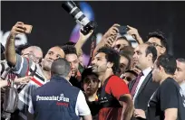  ??  ?? Fans take selfies with Egypt’s Mohamed Salah during the team’s training session at Cairo internatio­nal stadium on Saturday. — Reuters