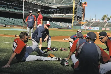  ?? Carlos Avila Gonzalez / The Chronicle ?? Washington manager MattWillia­ms (kneeling) chats with his players during an optional workout at AT&T Park on Sunday.