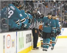  ?? Thearon W. Henderson / Getty Images ?? Logan Couture of the Sharks is congratula­ted by teammates after he scored the first goal of Game 3 in the first period.