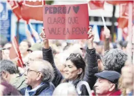  ?? ?? Una mujer sujeta una pancarta de apoyo a Pedro Sánchez, ayer.