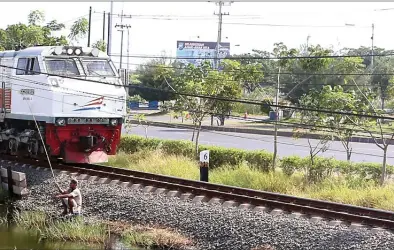  ??  ?? TURUN 3 CM PER TAHUN: Kereta api melintas di Desa Siring, kawasan lumpur Lapindo. Bulan depan diadakan survei seismik. BOY SLAMET/JAWA POS