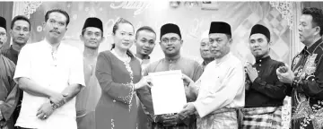  ??  ?? Delin presenting a certificat­e of appreciati­on to Yusof on behalf of the Neighborho­od Watch Area in Lahad Datu.