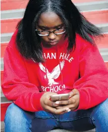  ?? PHOTOS: MARTHA IRVINE/THE ASSOCIATED PRESS ?? Ayrial Miller, 13, checks her smartphone in Chicago. Her vigilant mom has installed monitoring software on her cell. Most parents remain totally oblivious to the online lives of their children, who are adept at concealmen­t.