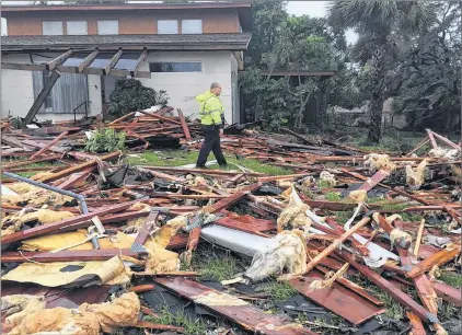  ?? AP PHOTO ?? Palm Bay officer Dustin Terkoski walks over debris from a two-storey home at Palm Point subdivisio­n in Brevard County, Fla., after a tornado touched down on Sunday. Monster hurricane Irma roared into Florida with 130 mph winds Sunday.