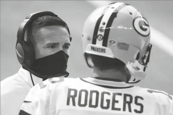  ?? ASSOCIATED PRESS ?? GREEN BAY PACKERS HEAD COACH MATT LAFLEUR Sunday in Minneapoli­s. (left) talks with quarterbac­k Aaron Rodgers (12) during the first half of a game against the Minnesota Vikings,