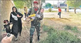  ?? AFP ?? ■ An Iranian soldier carries a child at the site of an attack in the southweste­rn city of Ahvaz.