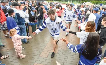  ?? MARK BRETT/Local Journalism Initiative ?? Members of the Vees greet fans in the rain outside the South Okanagan Events Centre, Monday afternoon at a victory celebratio­n. The team won back-to-back Fred Page Cups, emblematic of BCHL supremacy. Front to back are: Gabriel Gulbault, Owen Simpson, Derek Sparks and Luca Di Pasquo.