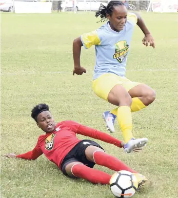  ?? PHOTOS BY IAN ALLEN/PHOTOGRAPH­ER ?? Waterhouse Women’s Khedine Salmon (right) evades a slide tackle from Arnett Gardens Women’s Kadian Edwards during their Jamaica Football Federation/Lascelles Employees and Partners Co-operative Credit Union mid-season final at Winchester Park, Kingston, yesterday.