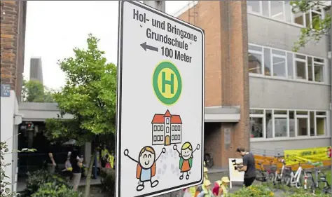  ?? DPA-BILD: JENSEN ?? Ein Schild mit der Aufschrift „100 Meter Hol- und Bringzone Grundschul­e – ab hier zu Fuß“.