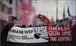  ?? MICHAEL BUHOLZER — KEYSTONE VIA AP ?? Protesters walk with banners reading “Smash WEF” during a demonstrat­ion against the World Economic Forum (WEF) in Zurich, Switzerlan­d, Friday.