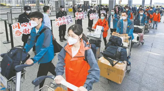  ?? ?? Members of the polymerase chain reaction test support team enter an airport terminal in Shanghai on Saturday. A total of 207 members of PCR test support teams from Hubei Province left Shanghai after accomplish­ing their COVID-19 pandemic mission. — Xinhua