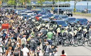  ??  ?? PEDALING INTO TROUBLE: Protesters stop traffic on the southbound FDR Drive near East 96th Street Saturday as warm, sunny weather brought out activists marching from the nearby 24th Precinct station house. Also on Saturday, graffiti vandals took out their anger on St. Patrick’s Cathedral (inset), while on Friday night a Brooklyn protester smacked a police car.