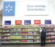  ?? AP PHOTO/JULIO CORTEZ ?? Walmart employee Kenneth White scans items while conducting an exercise during a Walmart Academy class session at the store in North Bergen, N.J., in 2017. Walmart will be rolling out a program that allows its staff to check out customers and provide receipts right on the spot in the busiest sections of the store.