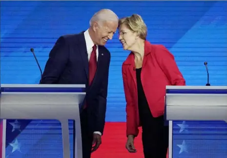  ?? David J. Philli/Associated Press ?? Democratic presidenti­al candidates former Vice President Joe Biden, left, and Sen. Elizabeth Warren, D-Mass., talk Thursday during a Democratic presidenti­al primary debate in Houston.