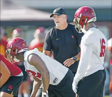  ?? Kent Nishimura Los Angeles Times ?? USC COACH Clay Helton works with players during fall camp. He’s focused on building depth and installing some other changes in response to last season’s loss against Ohio State in the Cotton Bowl.