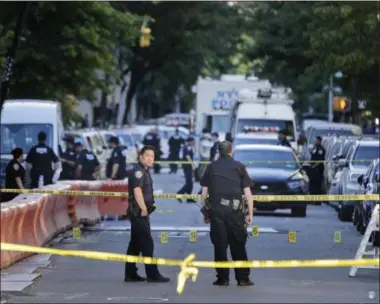  ?? SETH WENIG — THE ASSOCIATED PRESS ?? Numbers mark a crime scene near the site where a police officer was fatally shot in the Bronx section of New York, Wednesday. Police said other officers shot and killed the suspect after he drew a revolver on them.