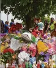  ?? ?? People walk by a memorial for the victims of the Buffalo supermarke­t shooting outside Tops market Saturday.