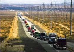  ?? IRFAN KHAN/LOS ANGELES TIMES/TNS ?? Truckers and supporters, calling themselves the People's Convoy, travel along Highway 395 on Wednesday in Adelanto, California.